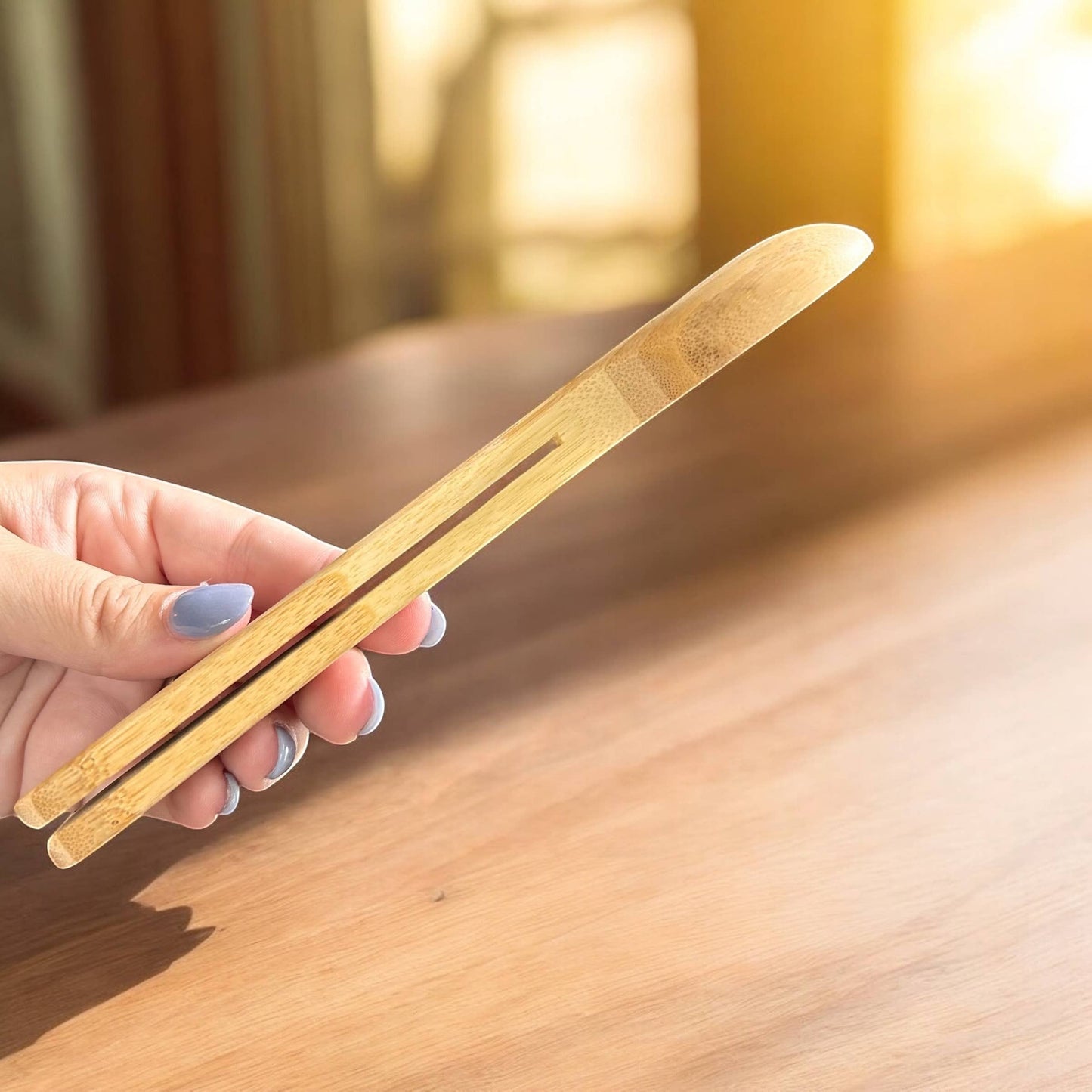 Bubble Gallery bamboo coffee scoop with integrated bag clip held in a hand for measuring coffee or tea