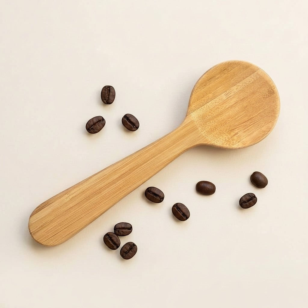 Bubble Gallery bamboo coffee scoop with integrated bag clip, shown with scattered roasted coffee beans.
