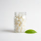 Bubble Gallery Cheeky Bits cloth wipe solution cubes in a glass jar. White, solid cubes made from castile soap and coconut oil.