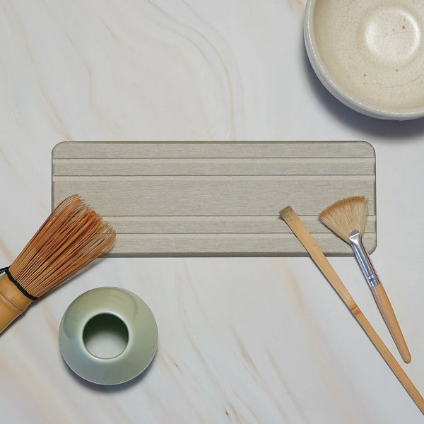 Bubble Gallery diatomaceous earth bottle tray in neutral grey with horizontal channels. Holds two soap dispensers and a bar.