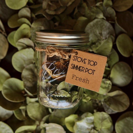 Bubble Gallery Fresh simmer pot in a glass mason jar with lavender, cardamom, lemon, and eucalyptus on eucalyptus leaves