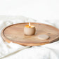 Bubble Gallery Cuties Candles by Sanctuary in a matte khaki mini tin with a wooden wick burning on a wooden tray.