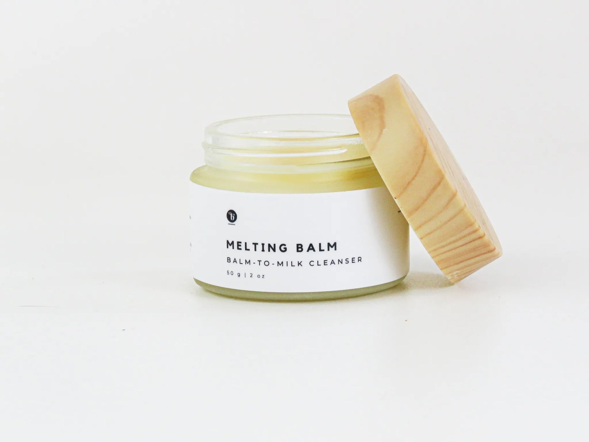Bubble Gallery Melting Balm cleanser in a glass jar with a wooden lid, for all skin types.