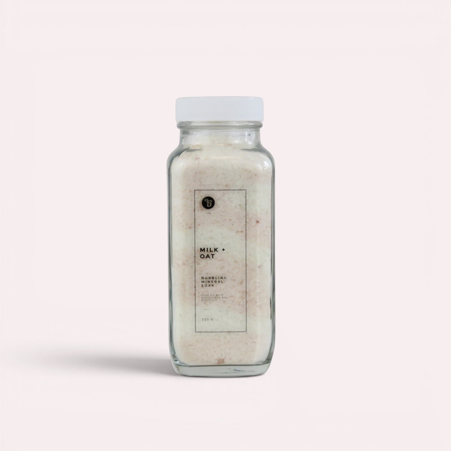 Bubble Gallery Milk + Oat Bubbling Magnesium Bath Soak in a glass jar with a white lid. Relaxing bath salts.