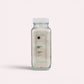 Bubble Gallery Milk + Oat Bubbling Magnesium Bath Soak in a glass jar with a white lid. Relaxing bath salts.