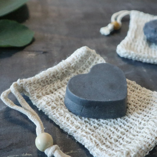 Bubble Gallery rebalancing shampoo and conditioner bar set with heart-shaped and round charcoal bars in mesh bags.
