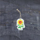 Bubble Gallery sunflower pop-up sponge with a hanging string on a dark textured background