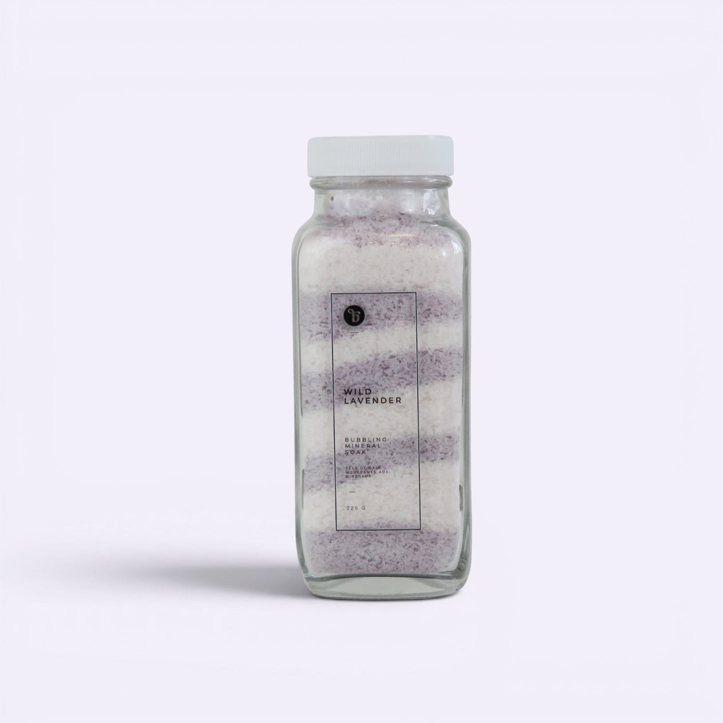 Bubble Gallery Wild Lavender Bubbling Magnesium Bath Soak in a glass jar with white lid, layered purple and white salts.