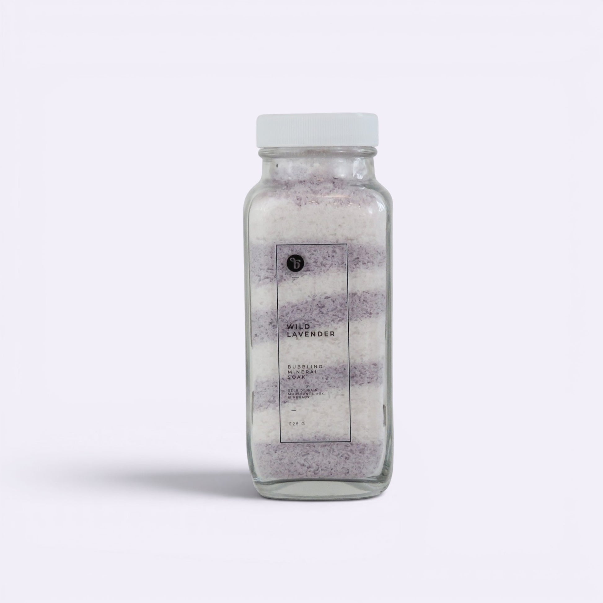 Bubble Gallery Wild Lavender Bubbling Magnesium Bath Soak in a glass jar with white lid, layered purple and white salts.